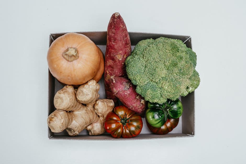 Fresh vegetables arranged in a cardboard delivery box