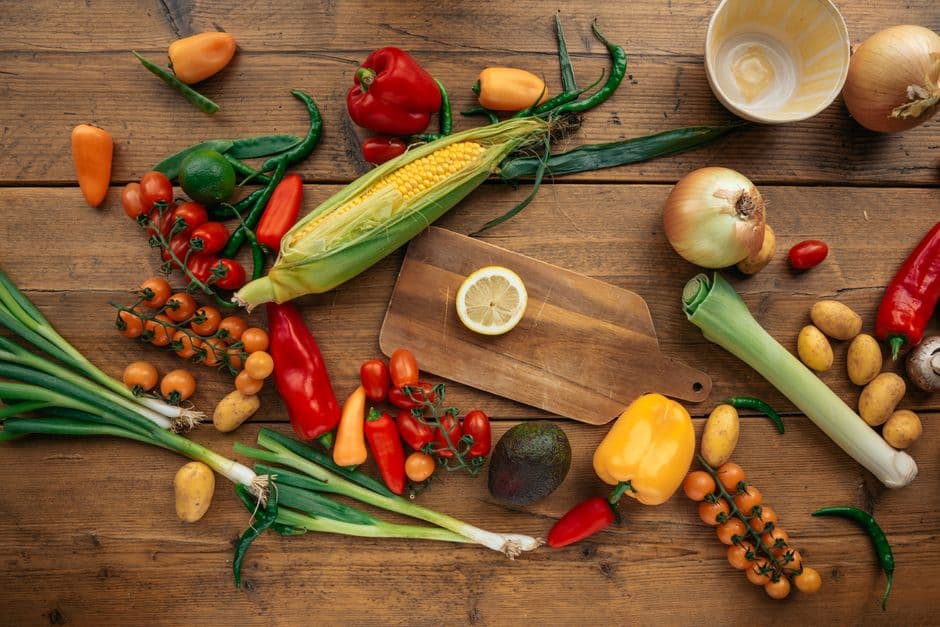 Colorful fresh ingredients spread across a wooden kitchen table